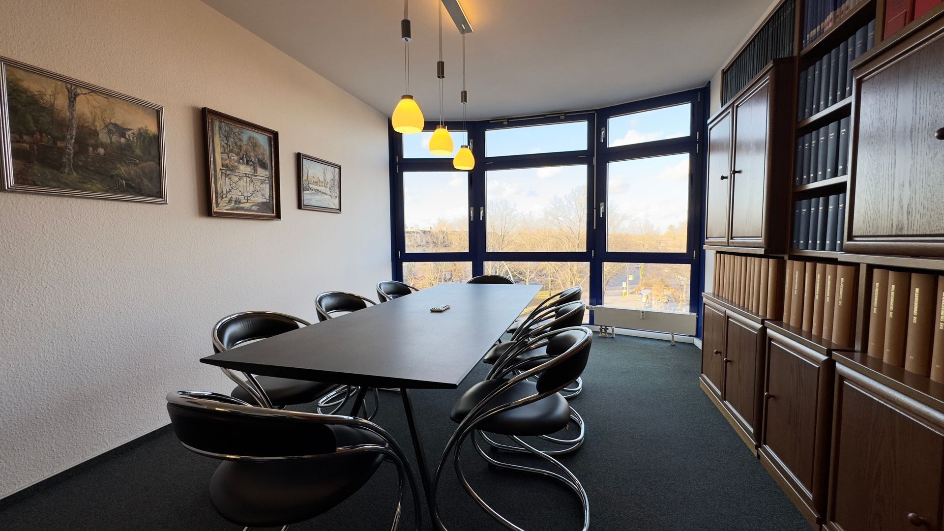 Ein Konferenzraum mit einem langen Tisch und Stühlen, in der Kanzlei Feuersänger