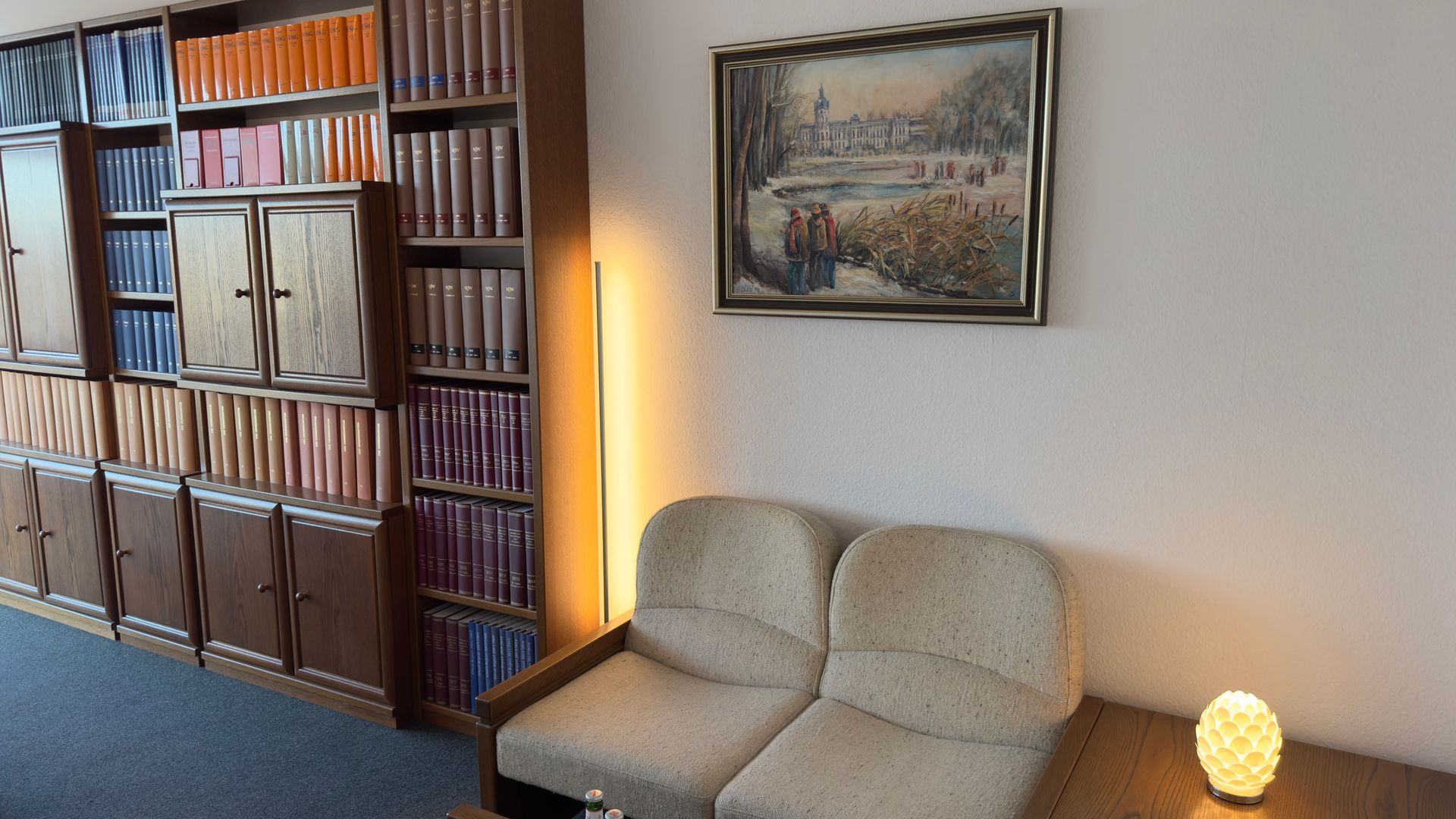 Ein Wohnzimmer mit einer Couch und einem Bild an der Wand, in der Kanzlei Feuersänger