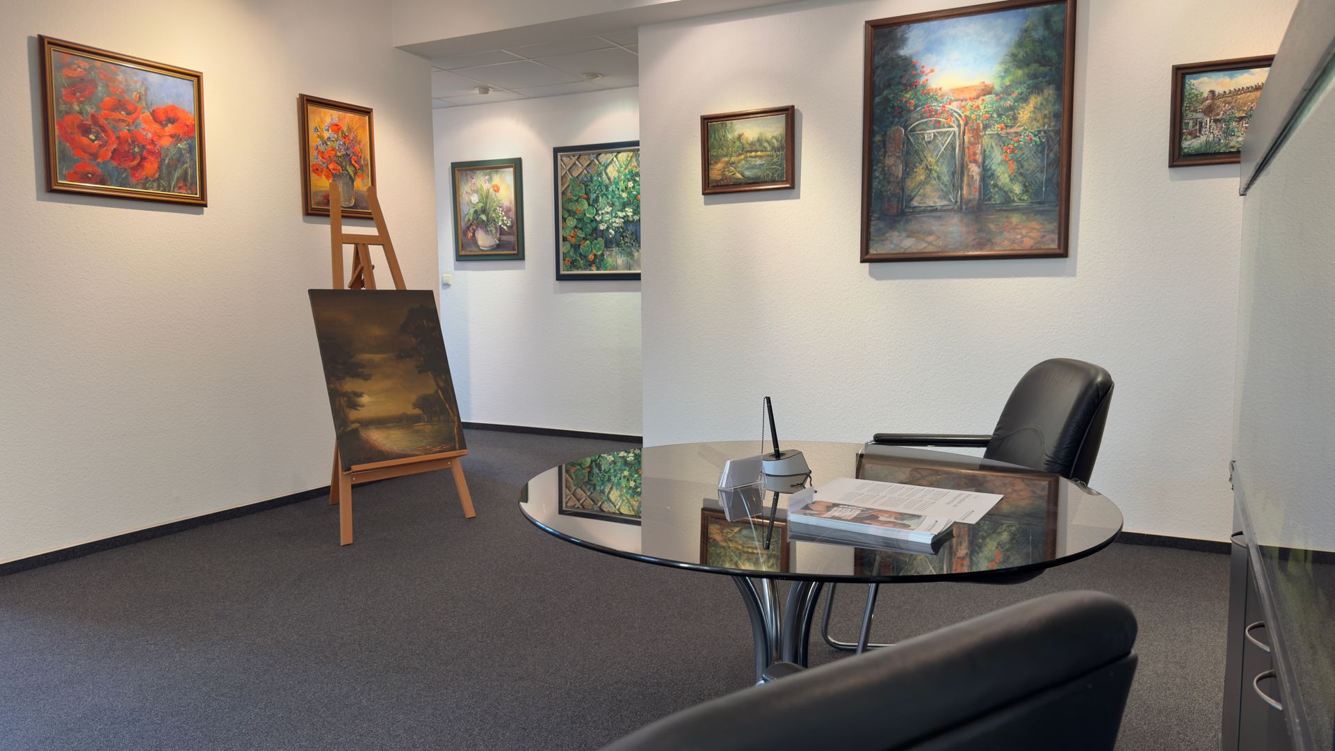 Ein Raum mit einem Tisch und Stühlen und Gemälden an der Wand, in der Kanzlei Feuersänger