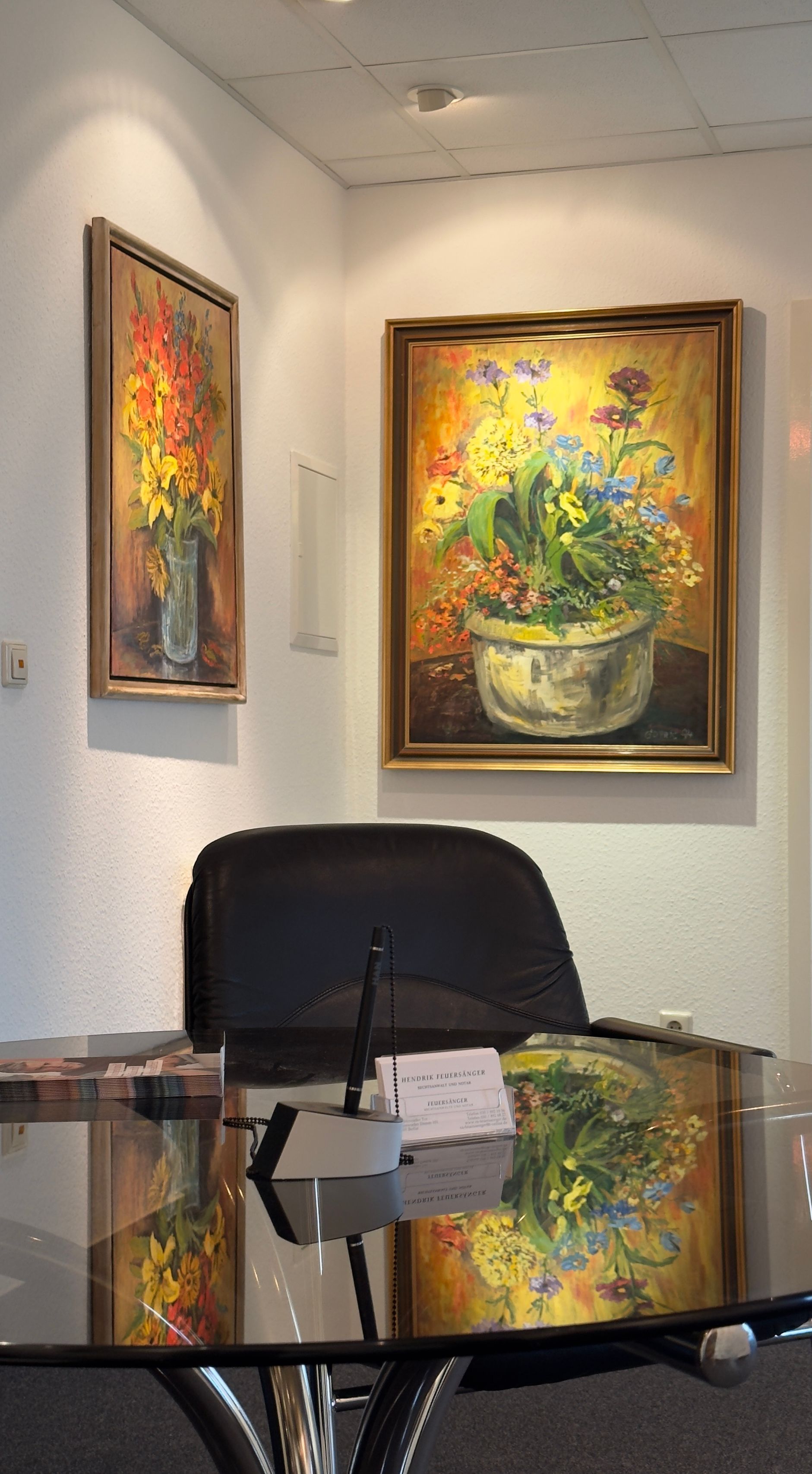 Ein Gemälde von Blumen in einer Vase hängt über einem Tisch, in der Kanzlei Feuersänger