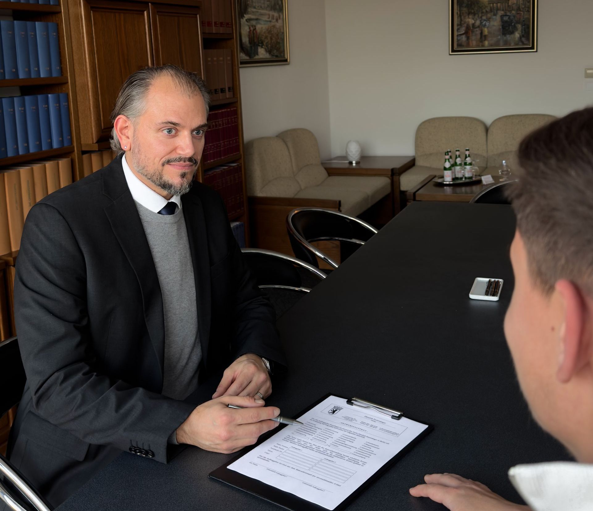 Ein Bild von dem Notar und Rechtsanwalt Hendrik Feuersänger, wie er in einem Gespräch mit einem Mandanten sitzt