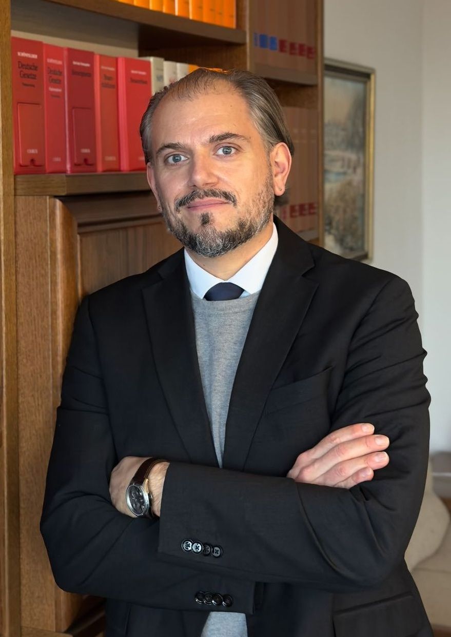 Ein Bild von dem Notar und Rechtsanwalt Hendrik Feuersänger, wie er vor einem Bücherregal in seiner Kanzlei steht