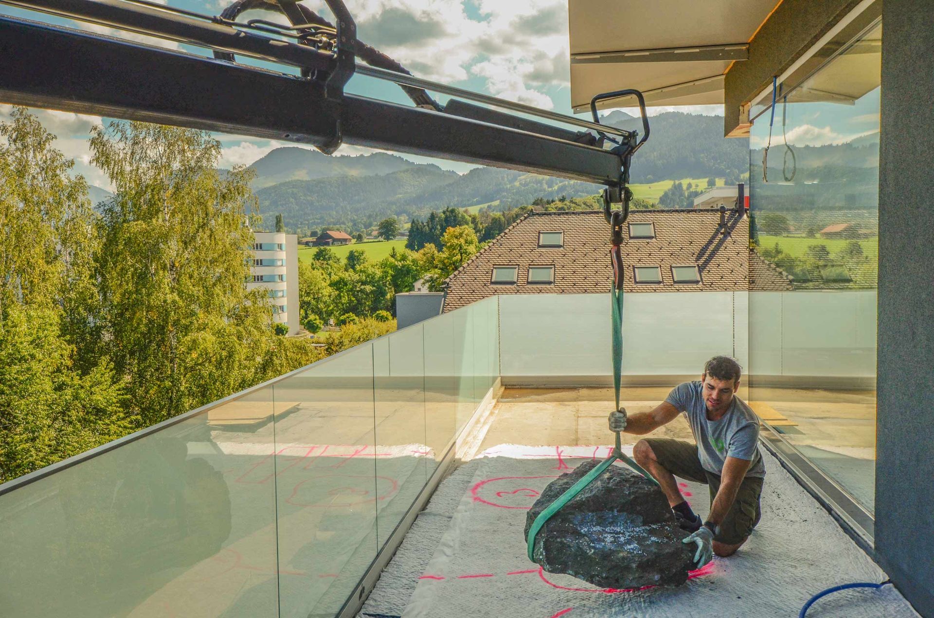 Un uomo sta lavorando su un balcone con una gru.