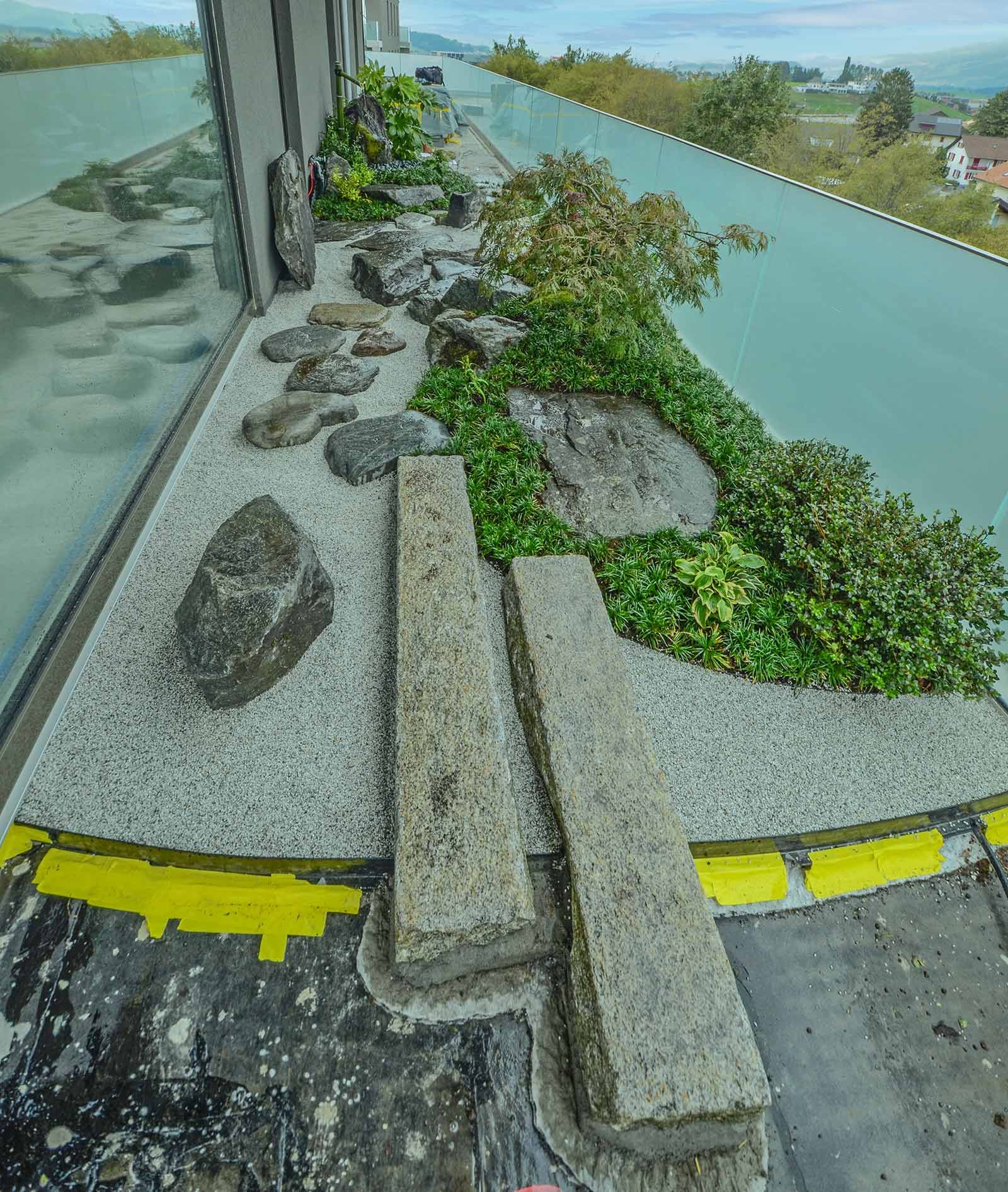 Un balcone con un sacco di rocce e piante sopra