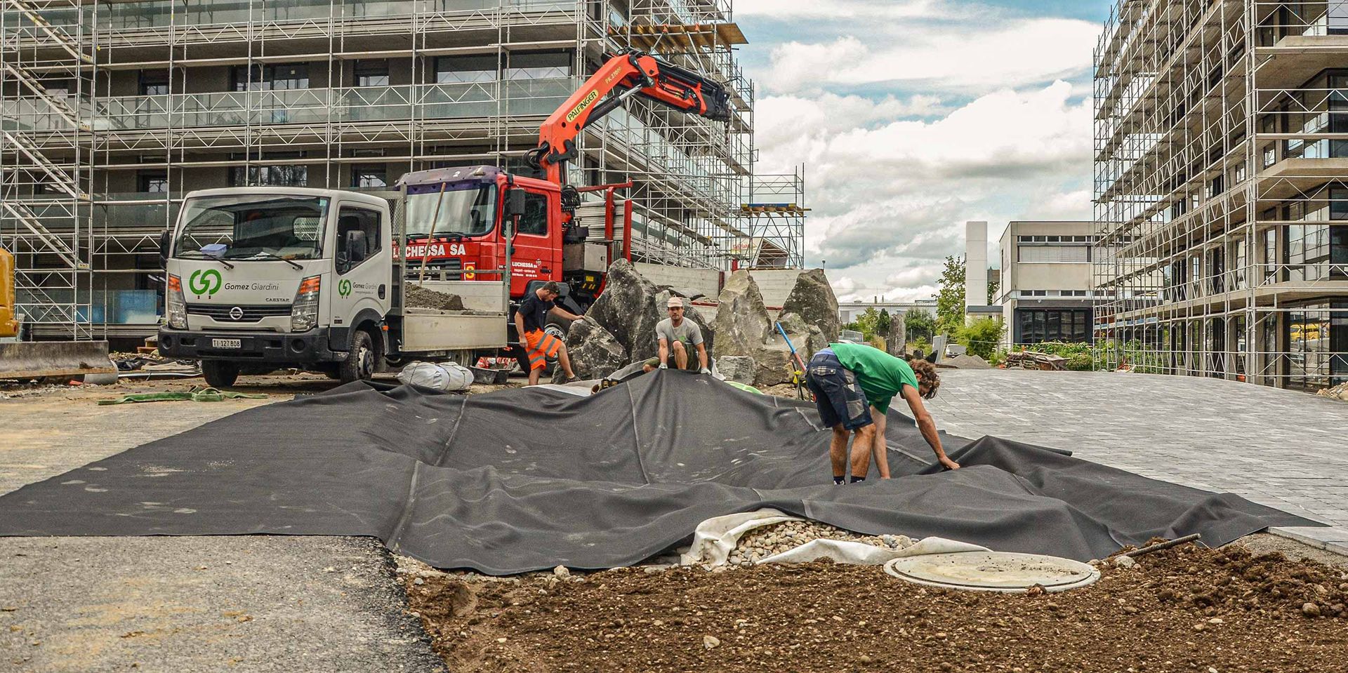 Un gruppo di operai edili sta lavorando in un cantiere posando uno stuoia.