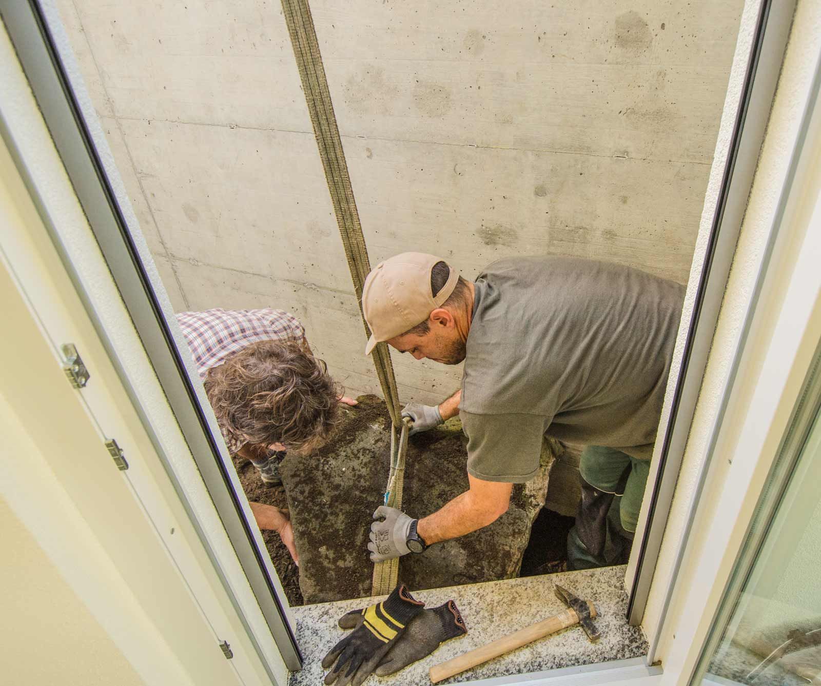 Un uomo sta posando una roccia in un giardino interrato.