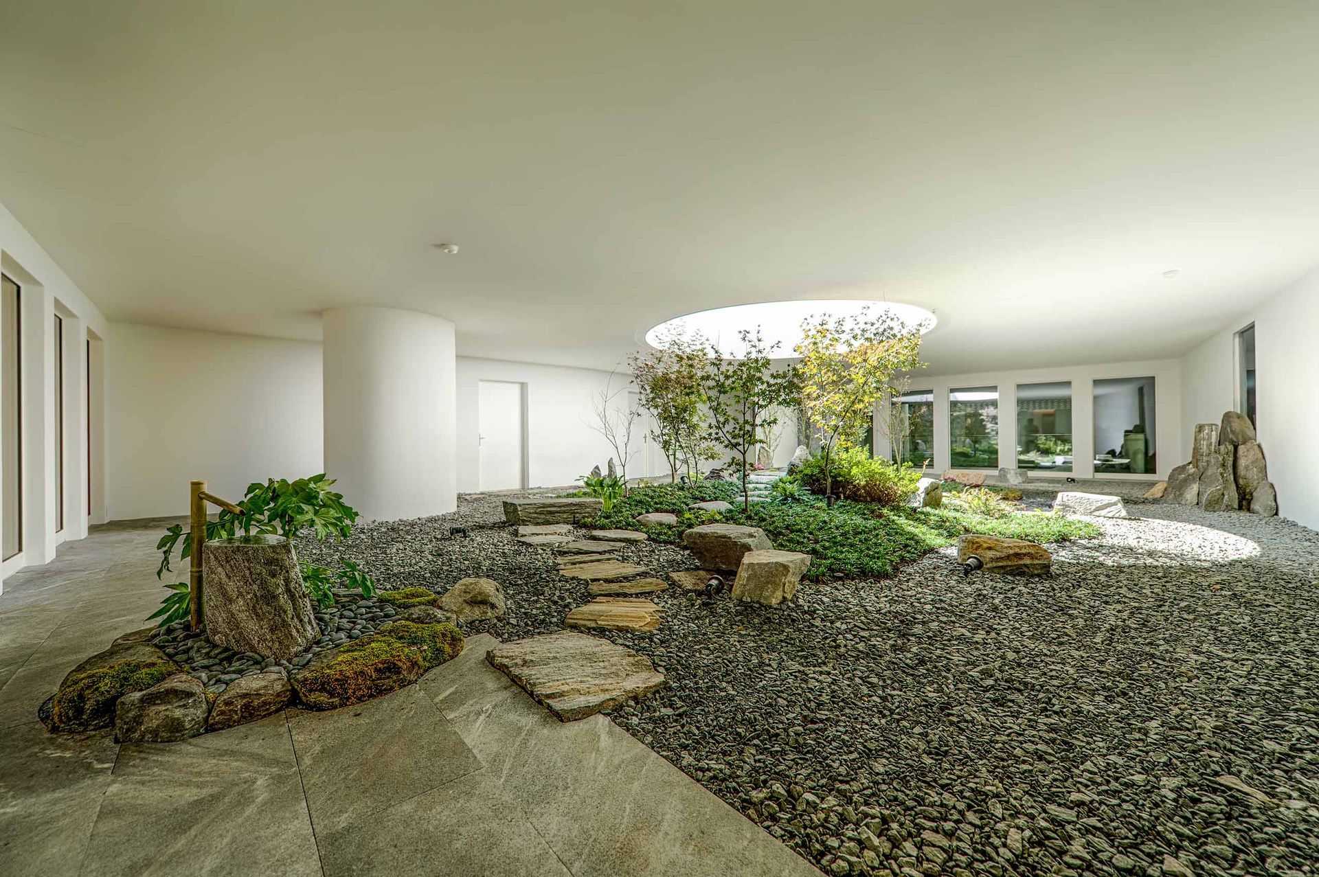 Una grande stanza con un giardino circolare al centro.