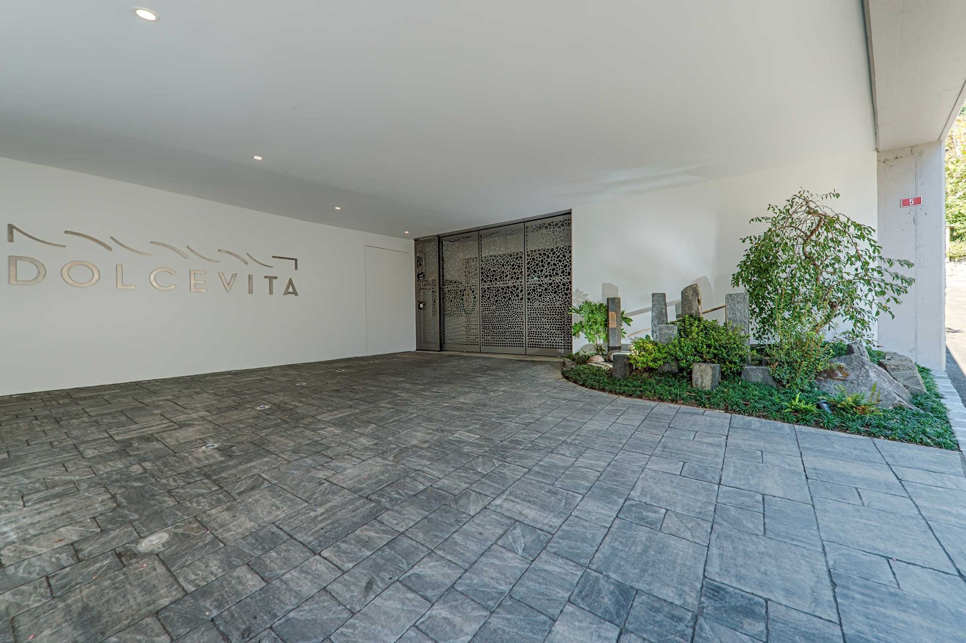 Un grande edificio bianco con un vialetto in mattoni che vi conduce.