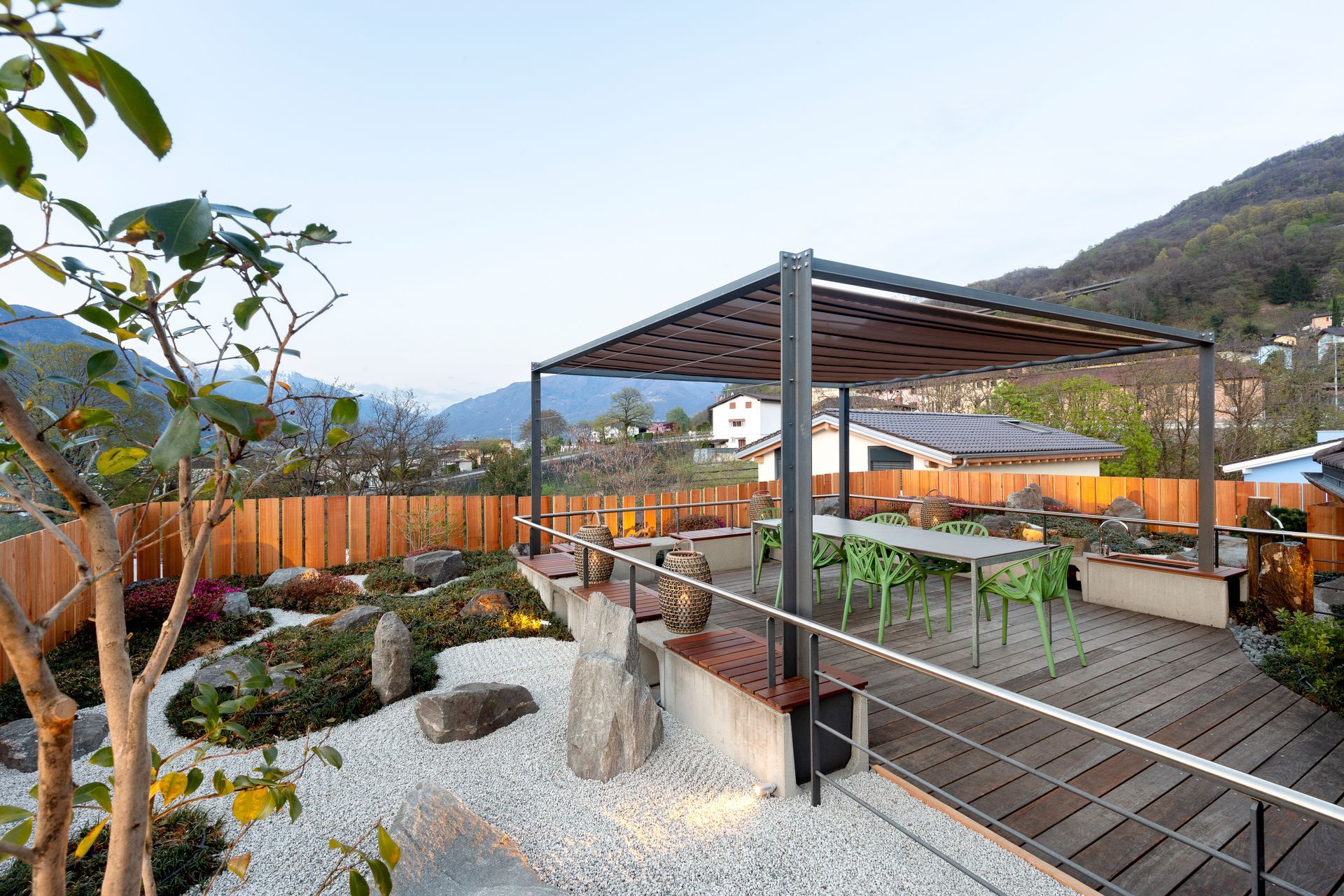 Un giardino sul tetto con pergolato, tavoli e sedie.