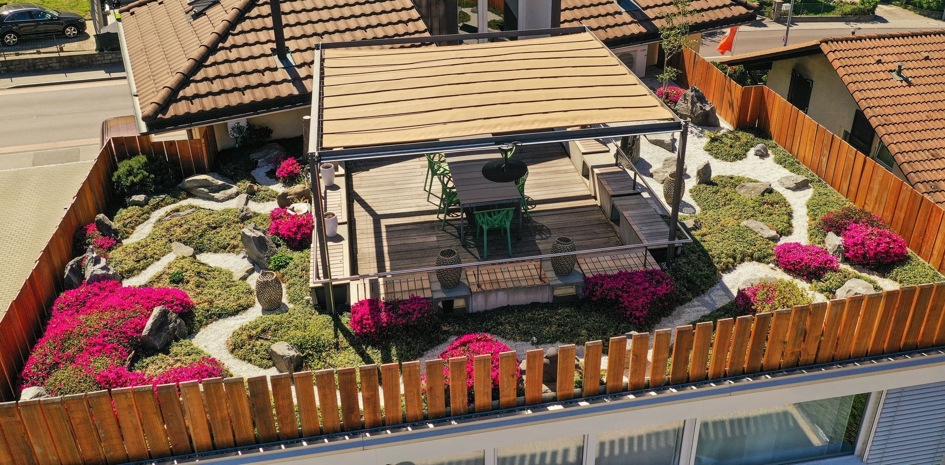 Una vista aerea di un giardino pensile con fiori e un pergolato.