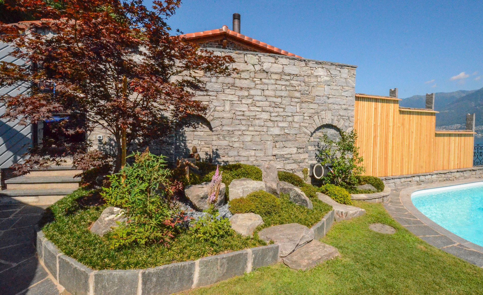 Un giardino armonico in una casa con una piscina di fronte