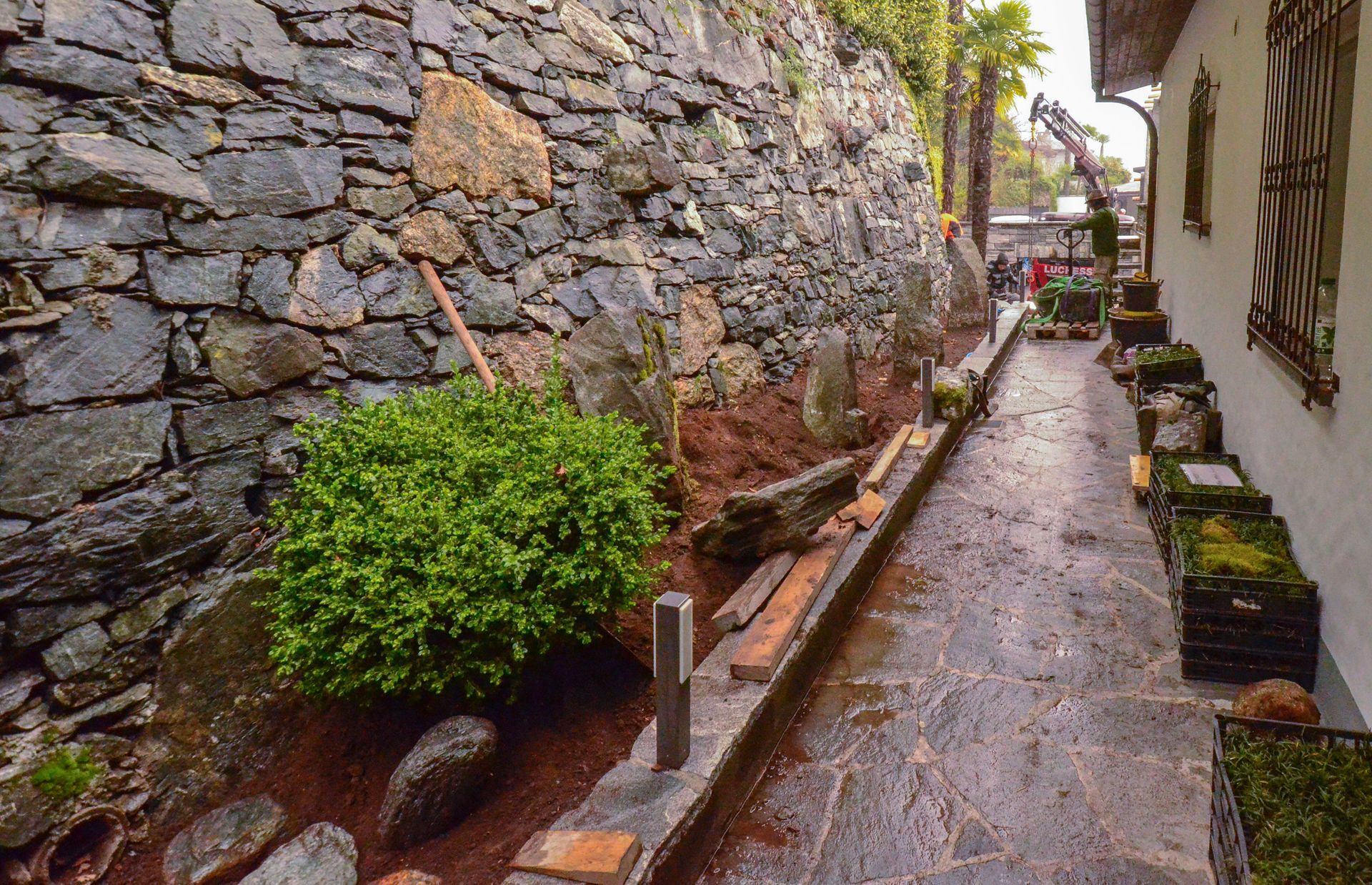 Un muro di pietra lungo un marciapiede accanto a una casa.