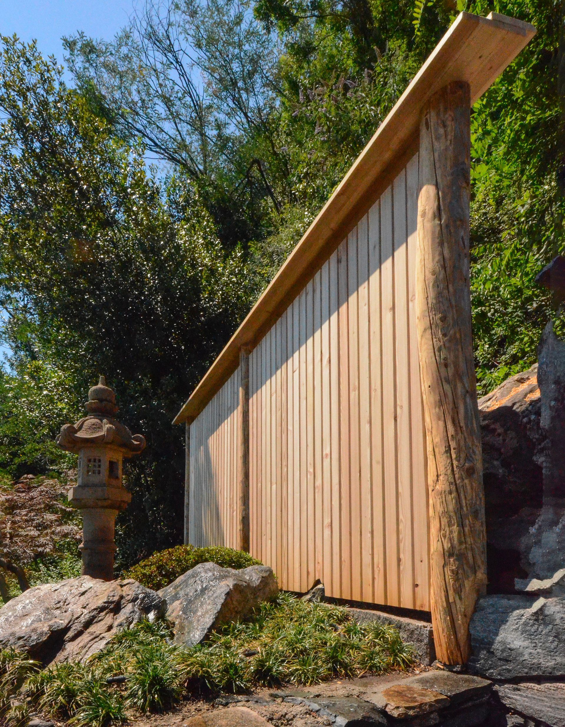 Una staccionata di legno con una lanterna giapponese sullo sfondo