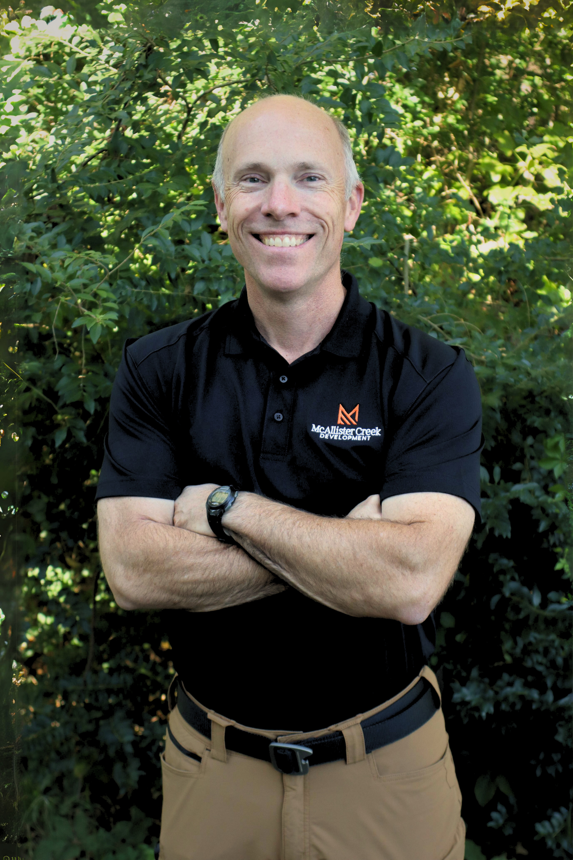 man smiling with arms crossed