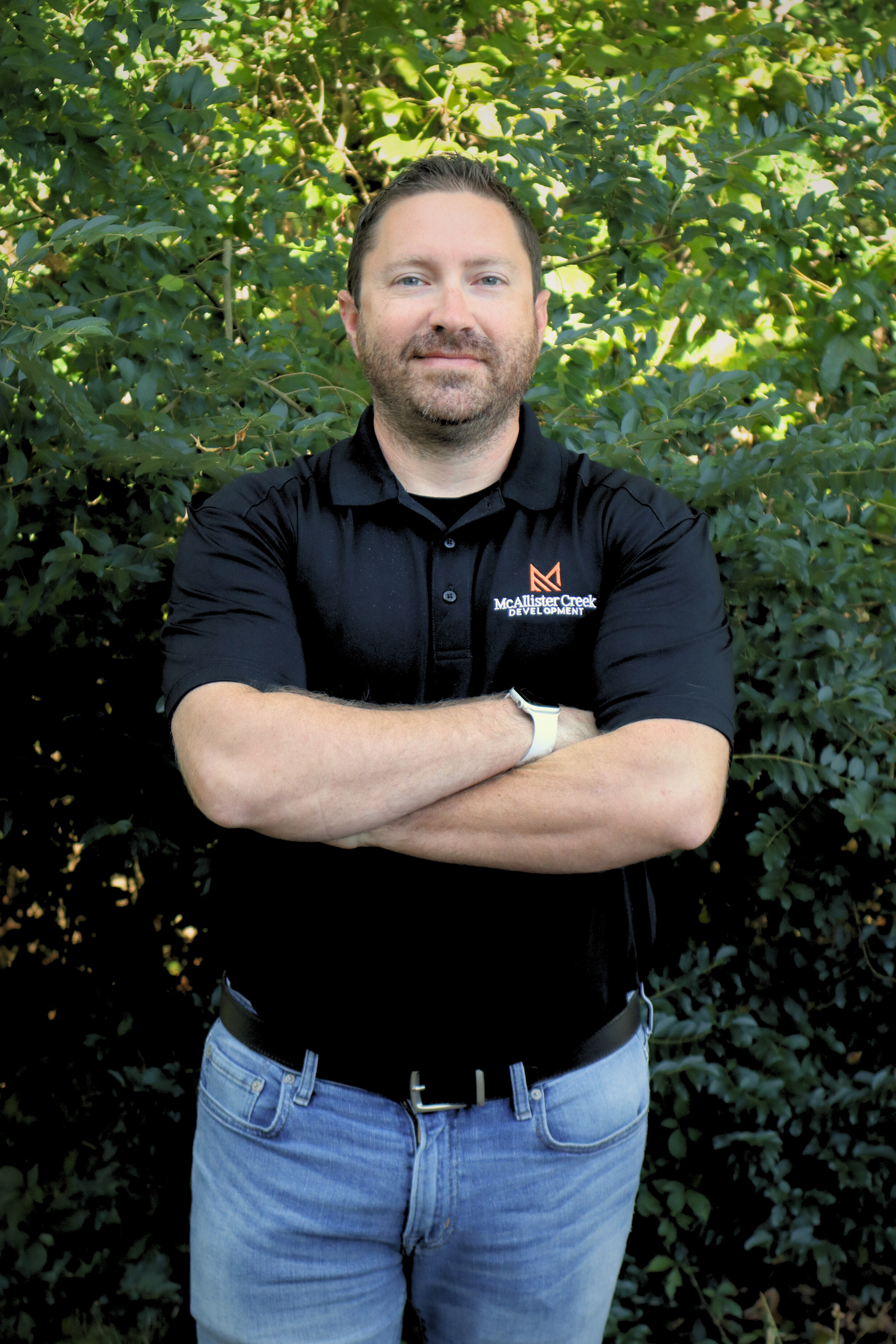 man smiling in front of trees