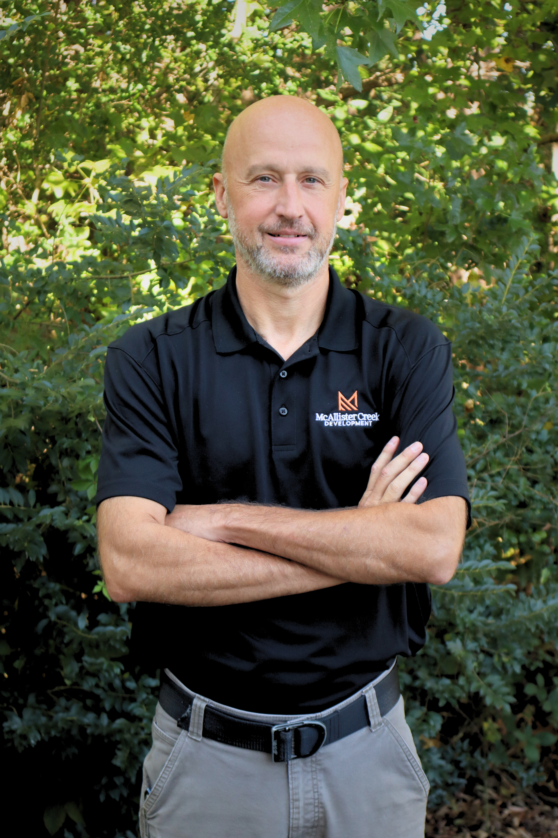man smiling with arms crossed