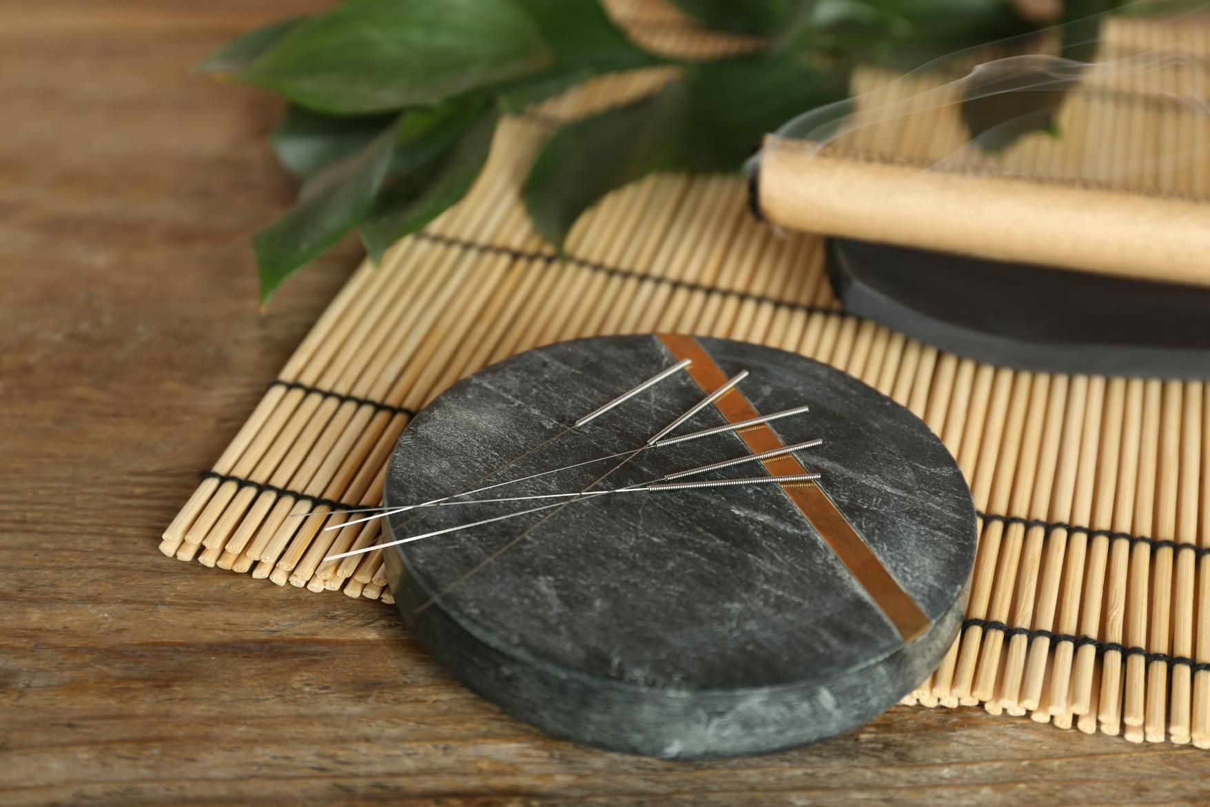 A Round Object is Sitting on a Bamboo Mat on a Wooden Table — Scott Martin Acupuncture Mackay In Cannonvale, QLD