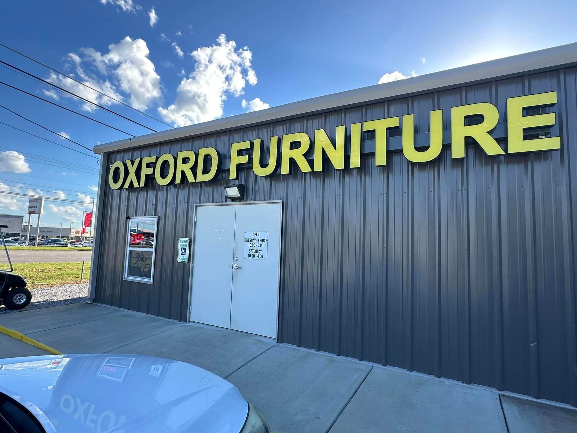 A car is parked in front of a building that says oxford furniture