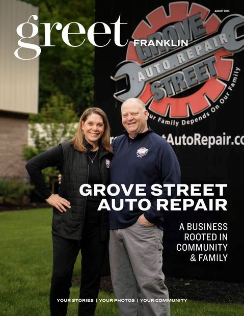 Grove Street Auto Repair sign with two smiling people standing outside in front of the building