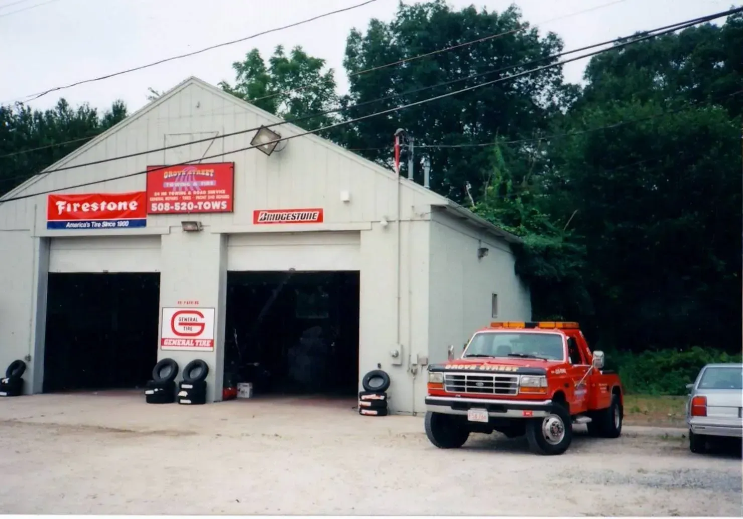 Small fire station garage with red trucks parked outside and signs above the bays