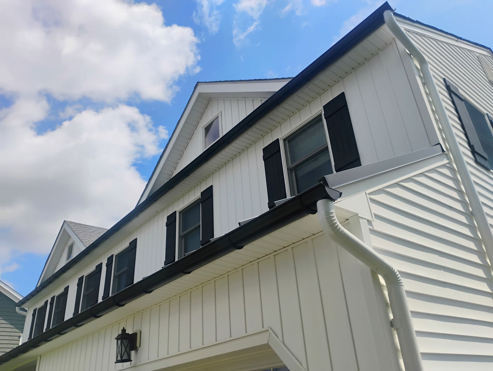 White home with black shutters and updated siding featured in our exterior renovation gallery.
