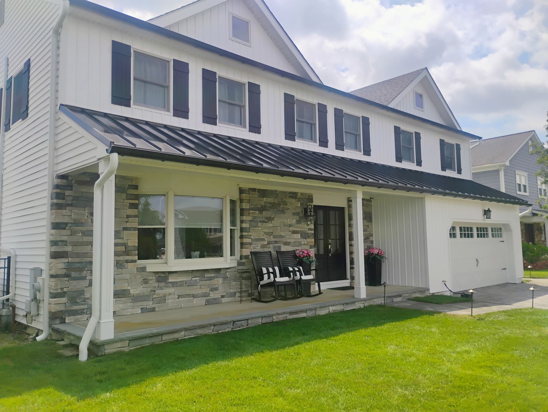 Two-story home with stone front, metal awning, and updated exterior featured in our project gallery.
