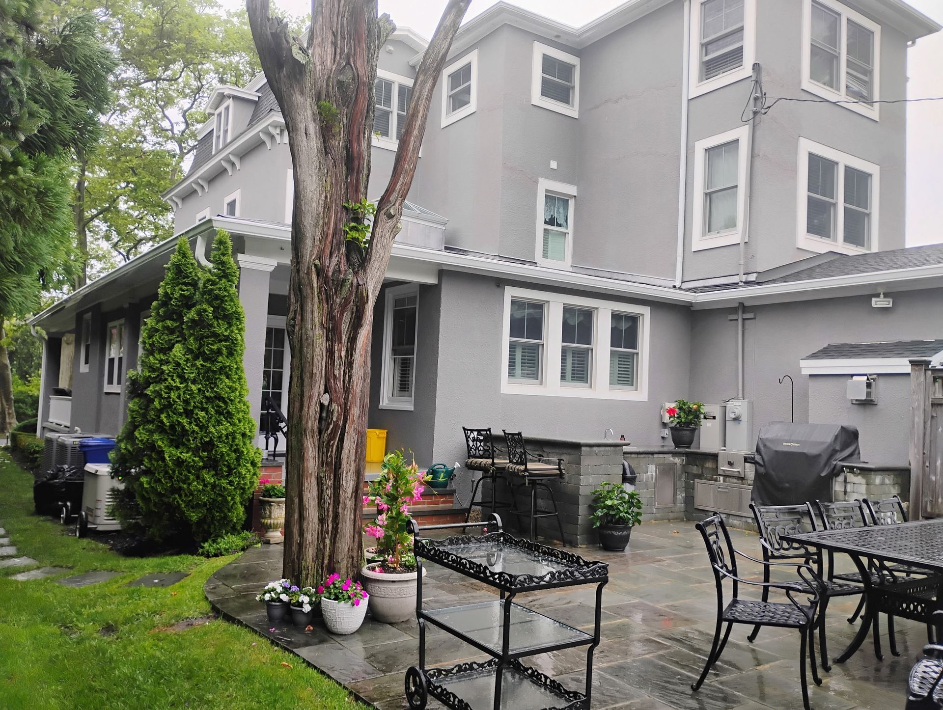 Gray residential home with updated siding and backyard patio improvements.
