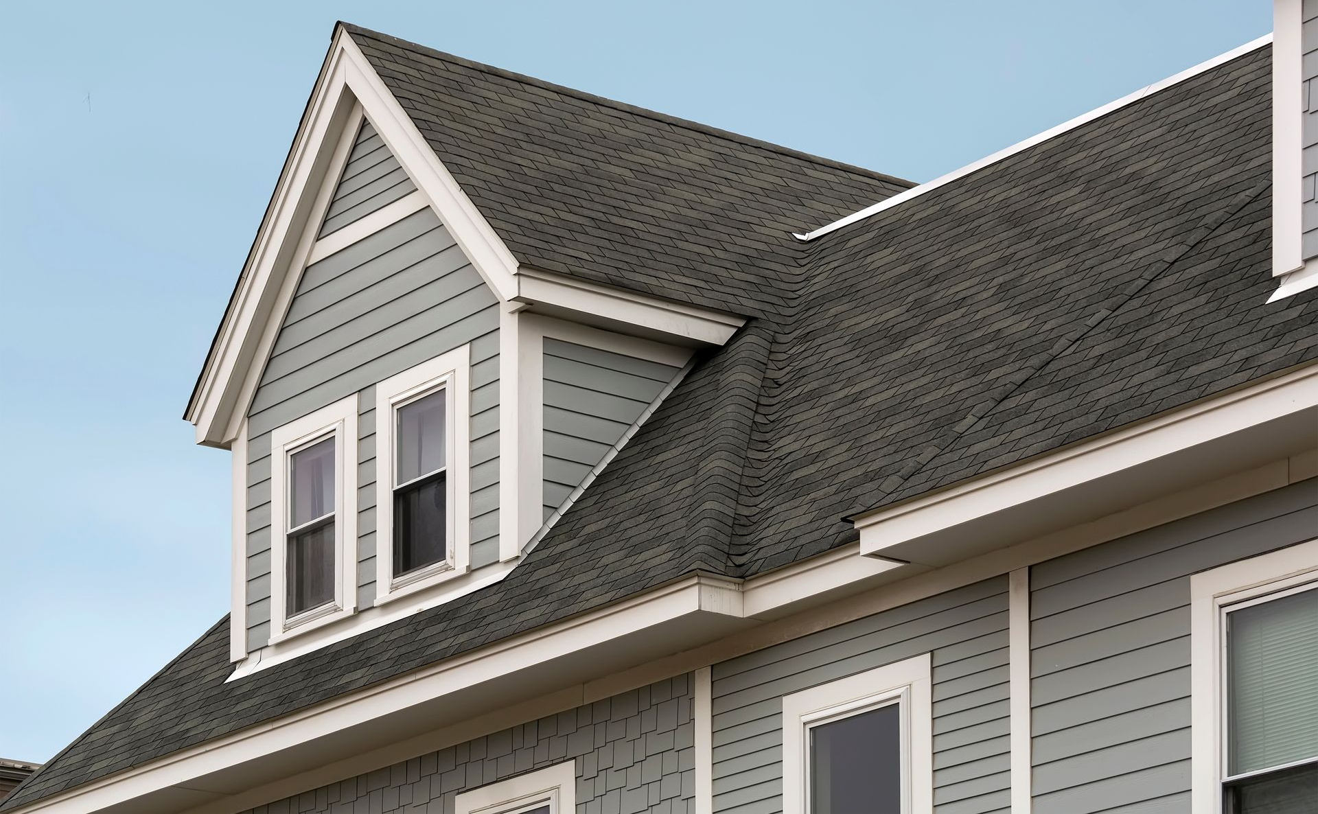 Home with new roofing, siding, and gutters representing exterior improvement services in NJ.
