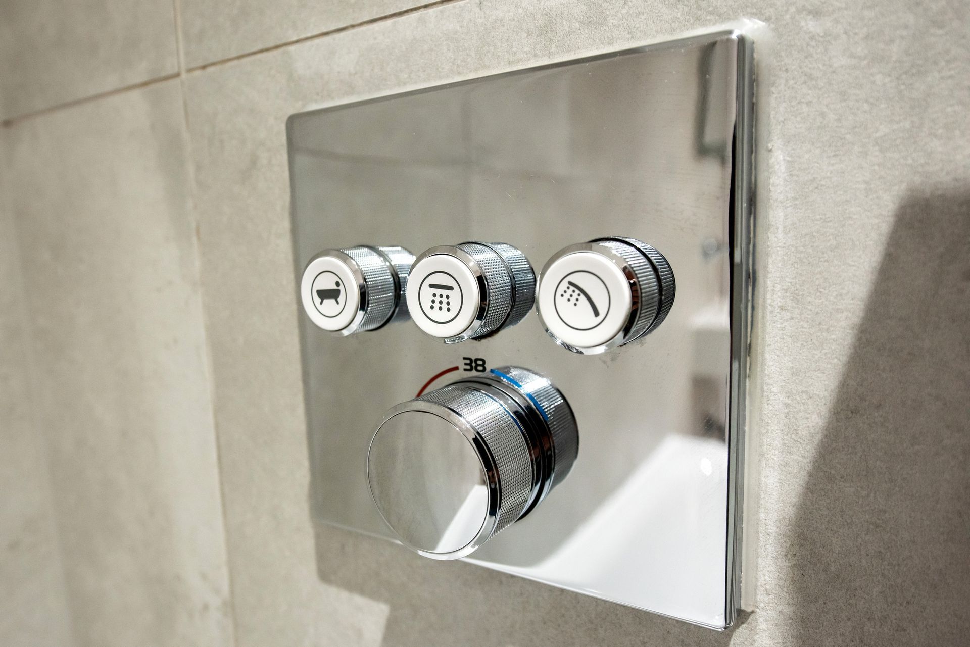 A close up of a shower head with three buttons on it