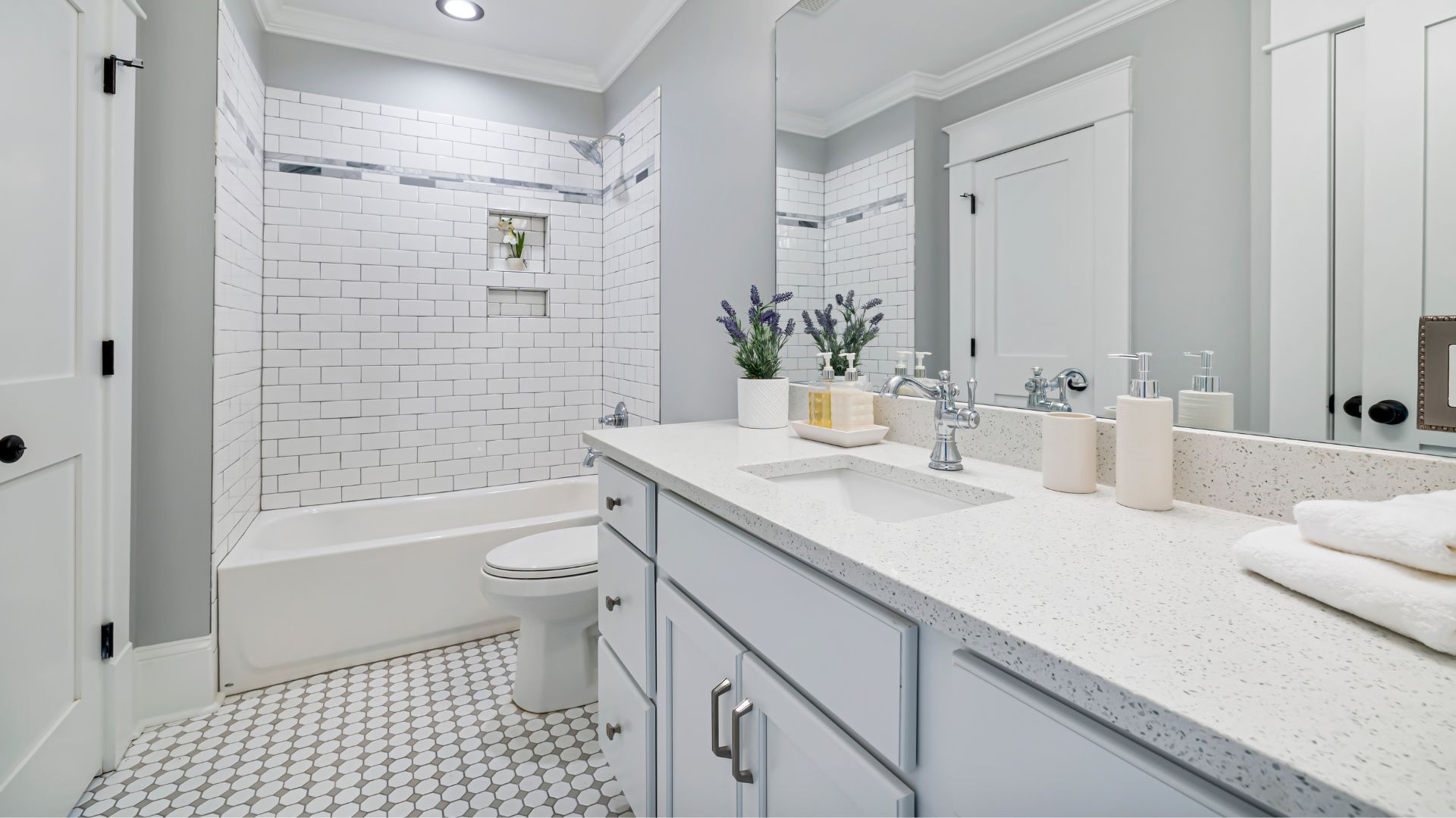 A bathroom with a sink , toilet , shower and mirror.