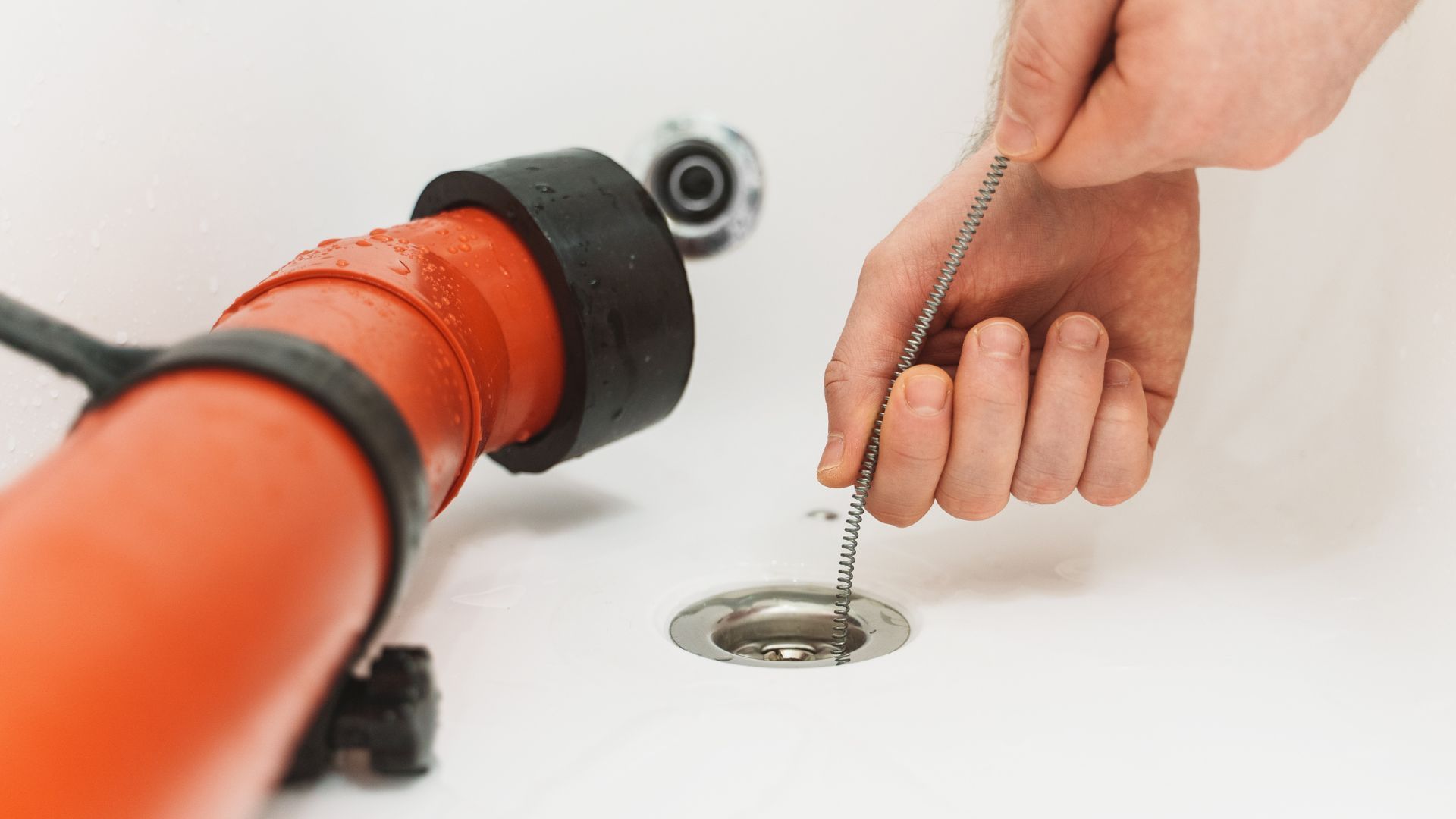 A person is cleaning a drain with a plunger.