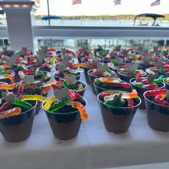 A bunch of cups filled with gummy worms on a table