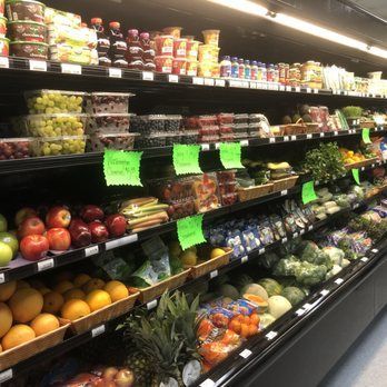 A grocery store aisle filled with fruits and vegetables.