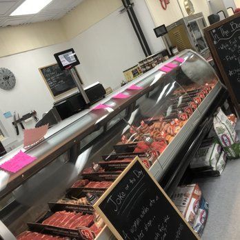 A butcher shop with a large display case filled with meat.