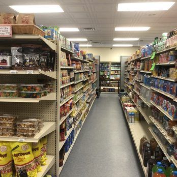A long aisle of a grocery store filled with lots of products.