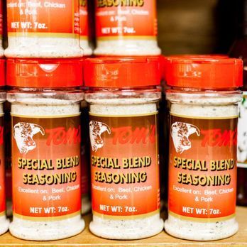 Three bottles of special blend seasoning are stacked on top of each other on a shelf.