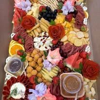 A large tray filled with lots of different types of food and flowers.