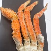 A bunch of crab legs sitting on top of a black plate.