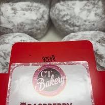A box of powdered sugar donuts from ct bakery.