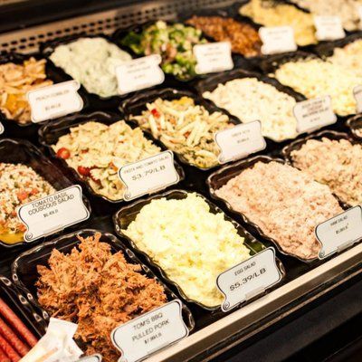 A display case filled with a variety of salads and meats