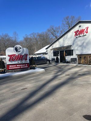 A white building with a red and white sign in front of it.