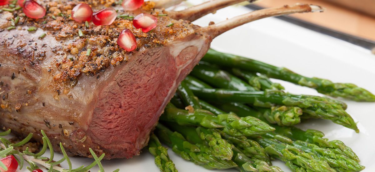 A close up of a piece of meat and asparagus on a plate.