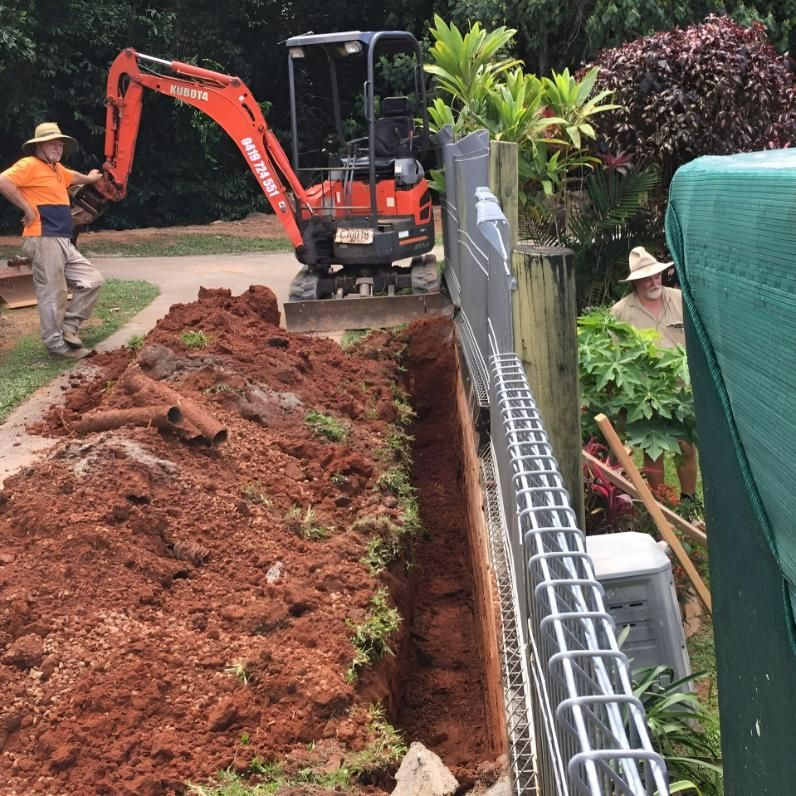 A Man in A Hat Is Standing Next to An Excavator that Says Kubota on It — J Newton Excavations in Bentley Park, QLD