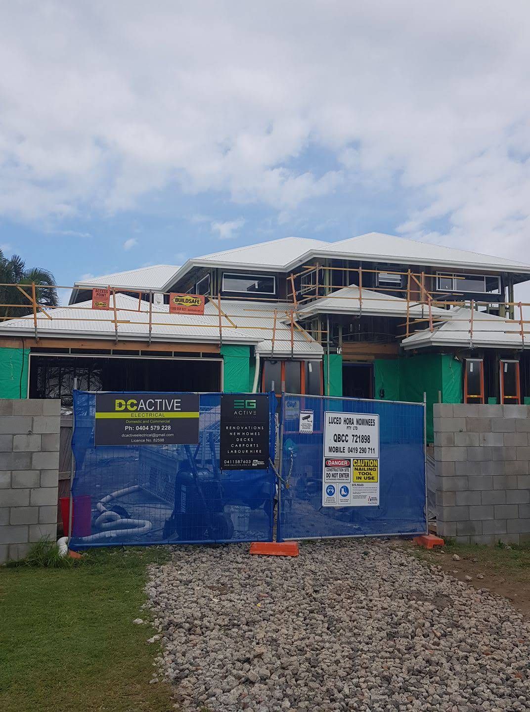 House Under Construction With Blue Fencing, Gravel Driveway — DC Active Electrical in Brighton, QLD