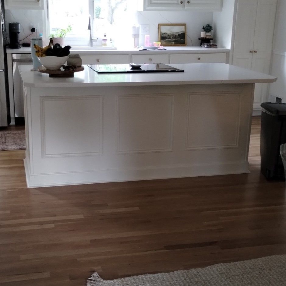 A kitchen with a large white island in the middle