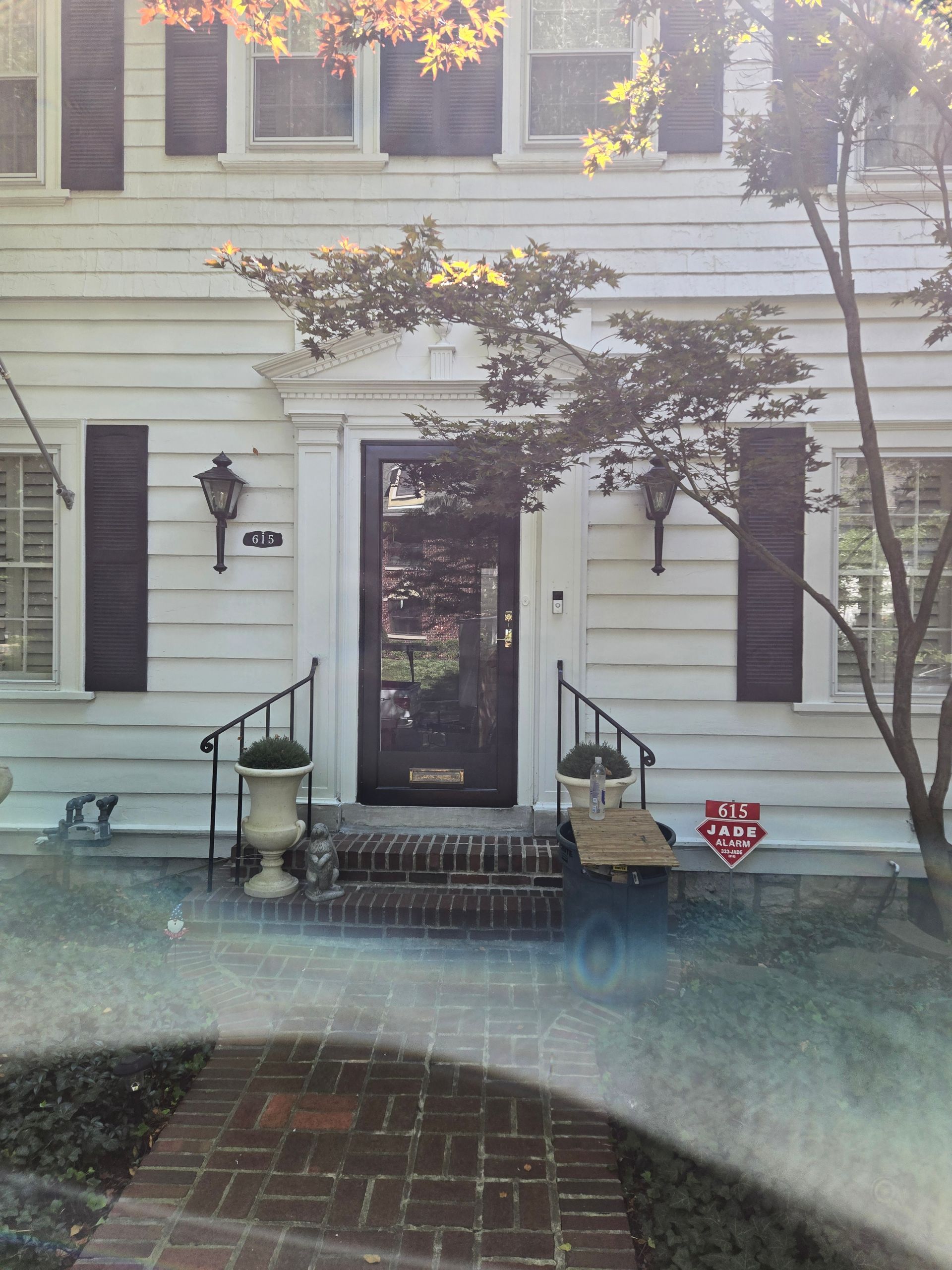 A porch with a wooden fence and a ceiling fan