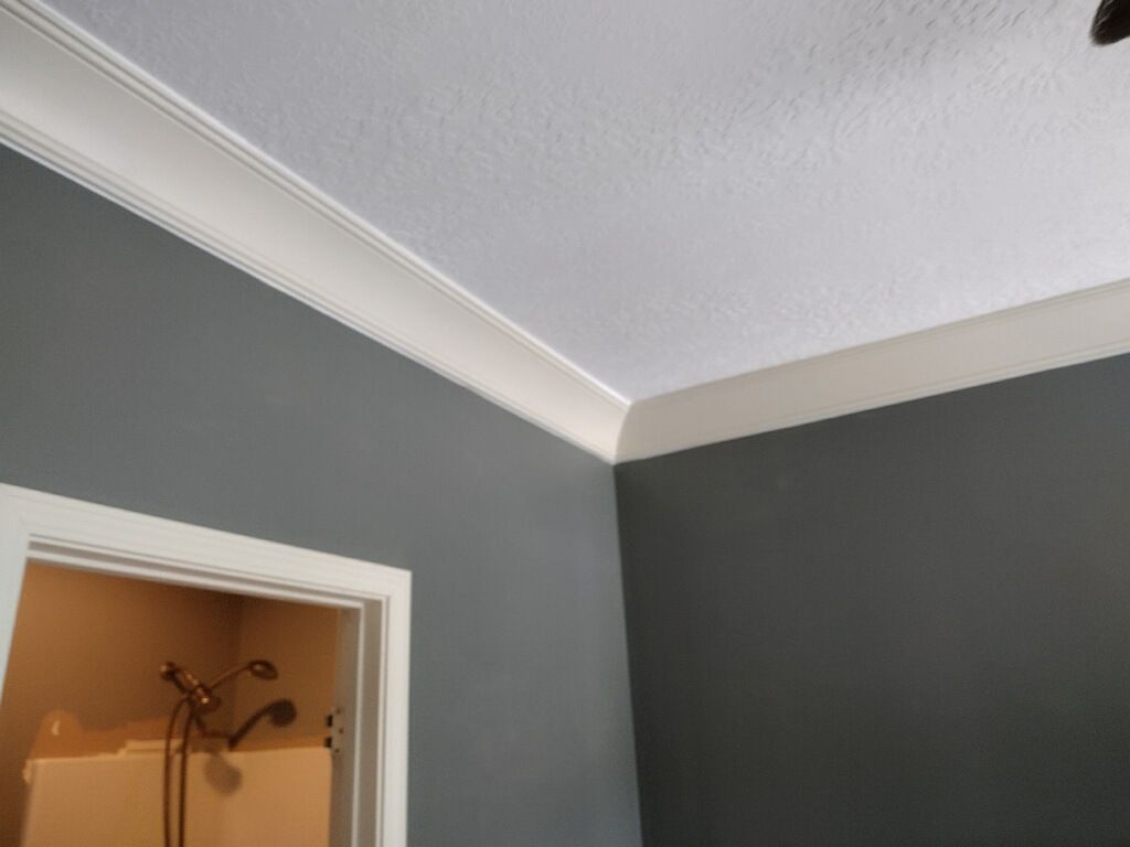 A bathroom with grey walls and white trim and a ceiling fan