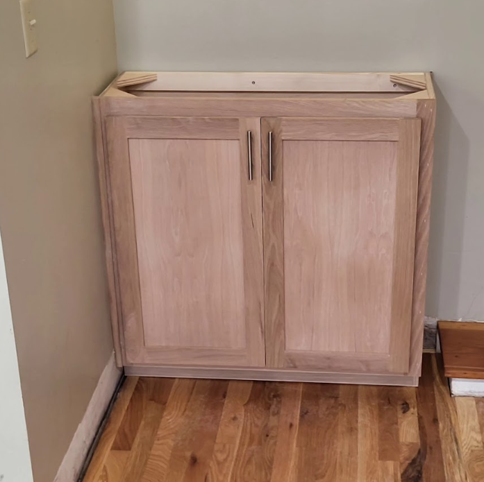 A wooden cabinet is sitting on a wooden floor in a room.