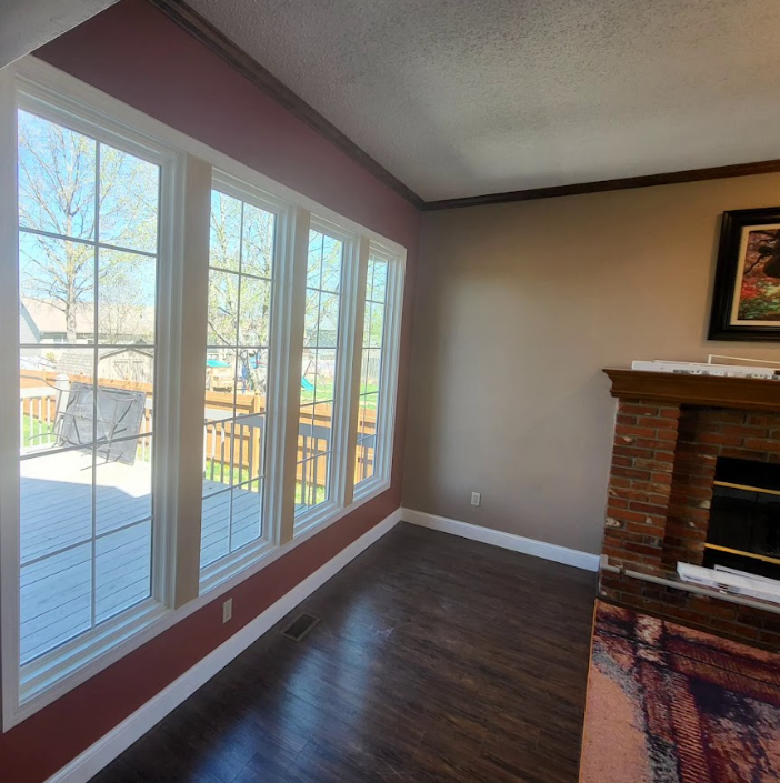 A living room with a fireplace and lots of windows