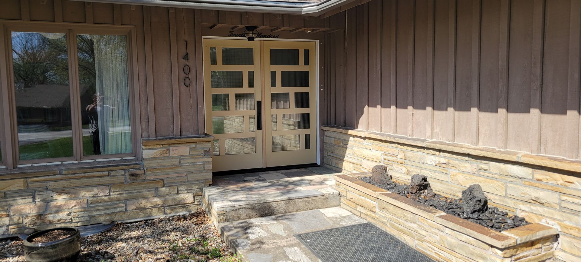 The front door of a house with a stone bench in front of it.